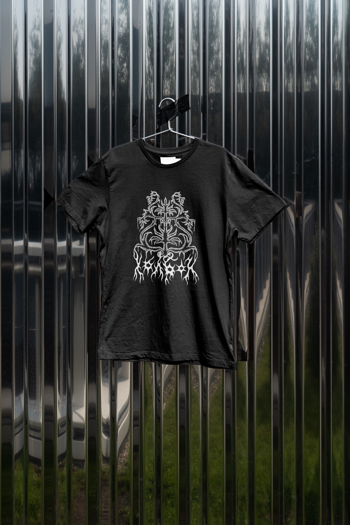 Black Holbon X T-shirt displayed against a reflective metal wall